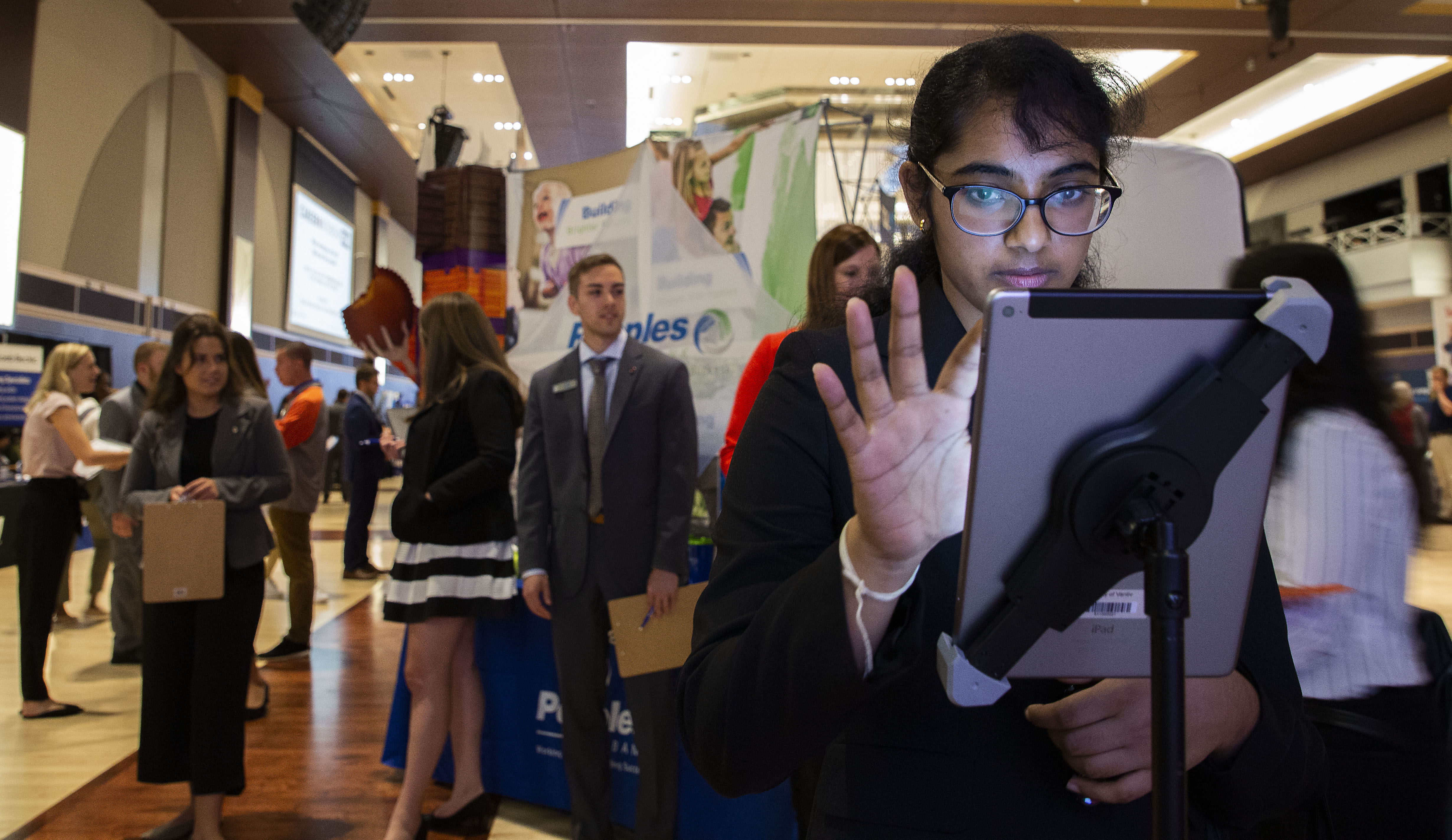A student fills out information at a recruiter table during day one of the Career and Internship Fair