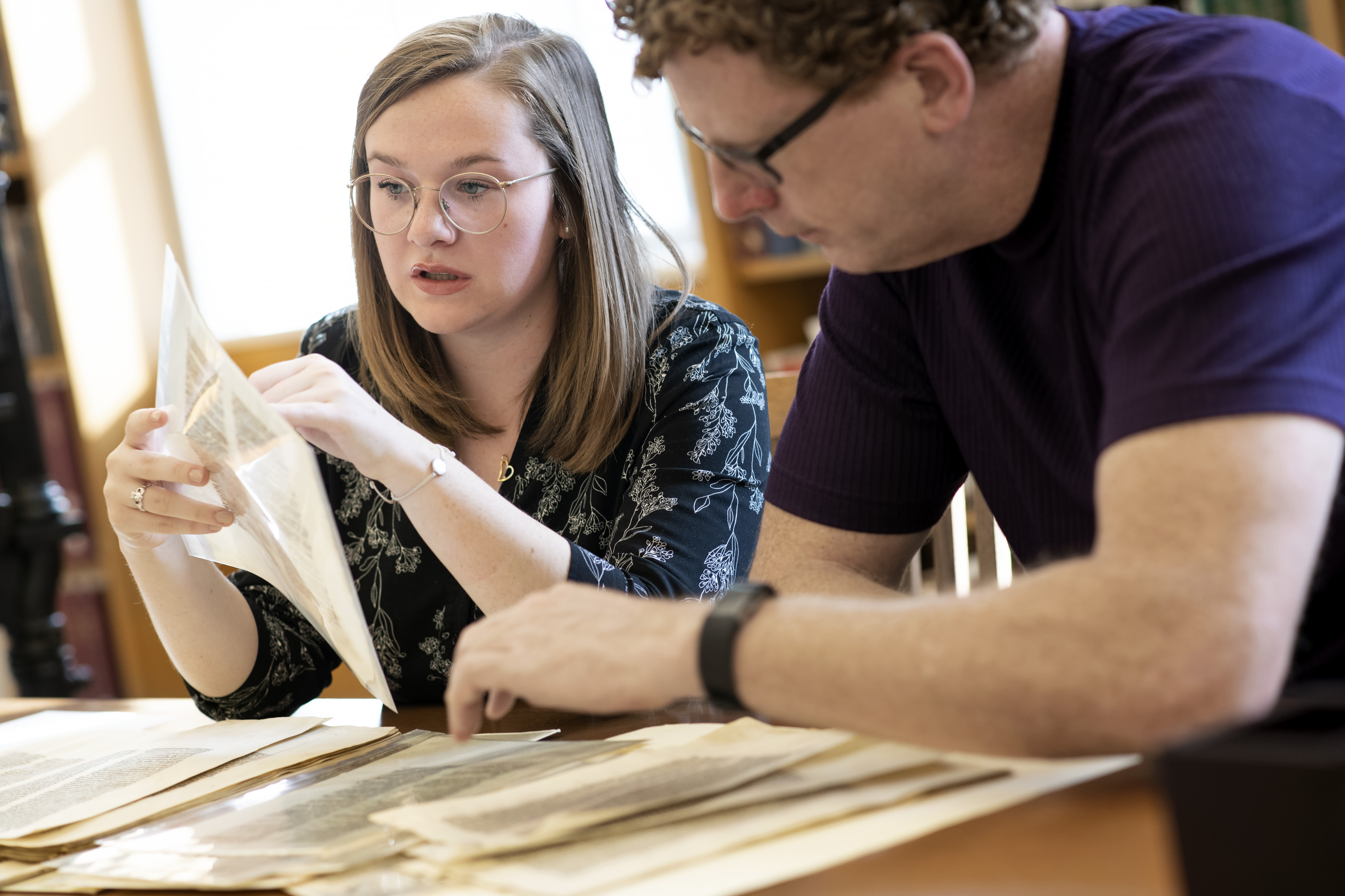 Undergraduate student Rose McCandless and her mentor Eric J. Johnson with leaves from a 13th Century Bible in the Rare Books and Manuscripts Library.