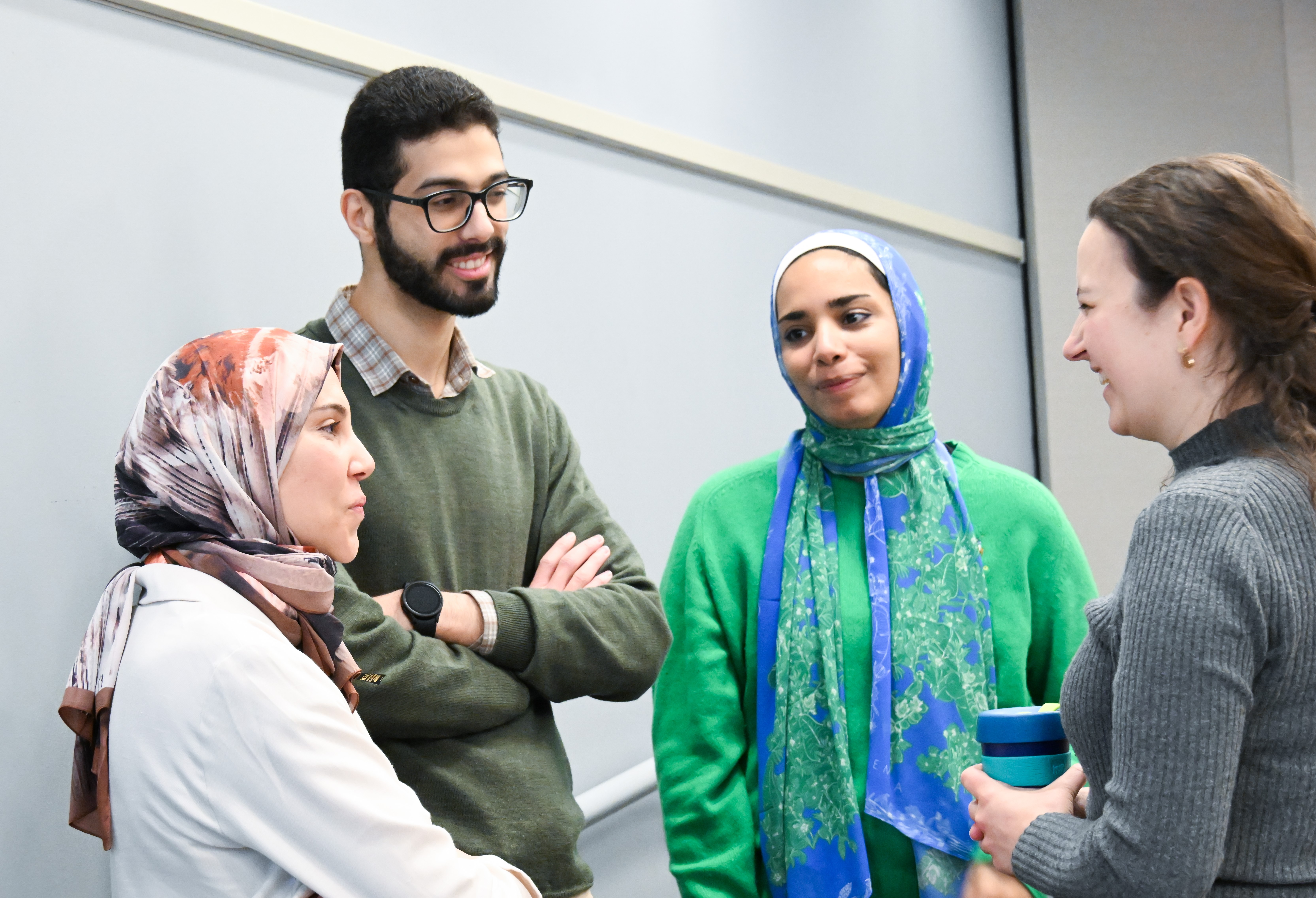 3 grad students speaking with one of their advisors