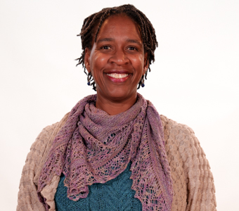 Portrait of Maria Miriti in a tan sweater with mauve scarf