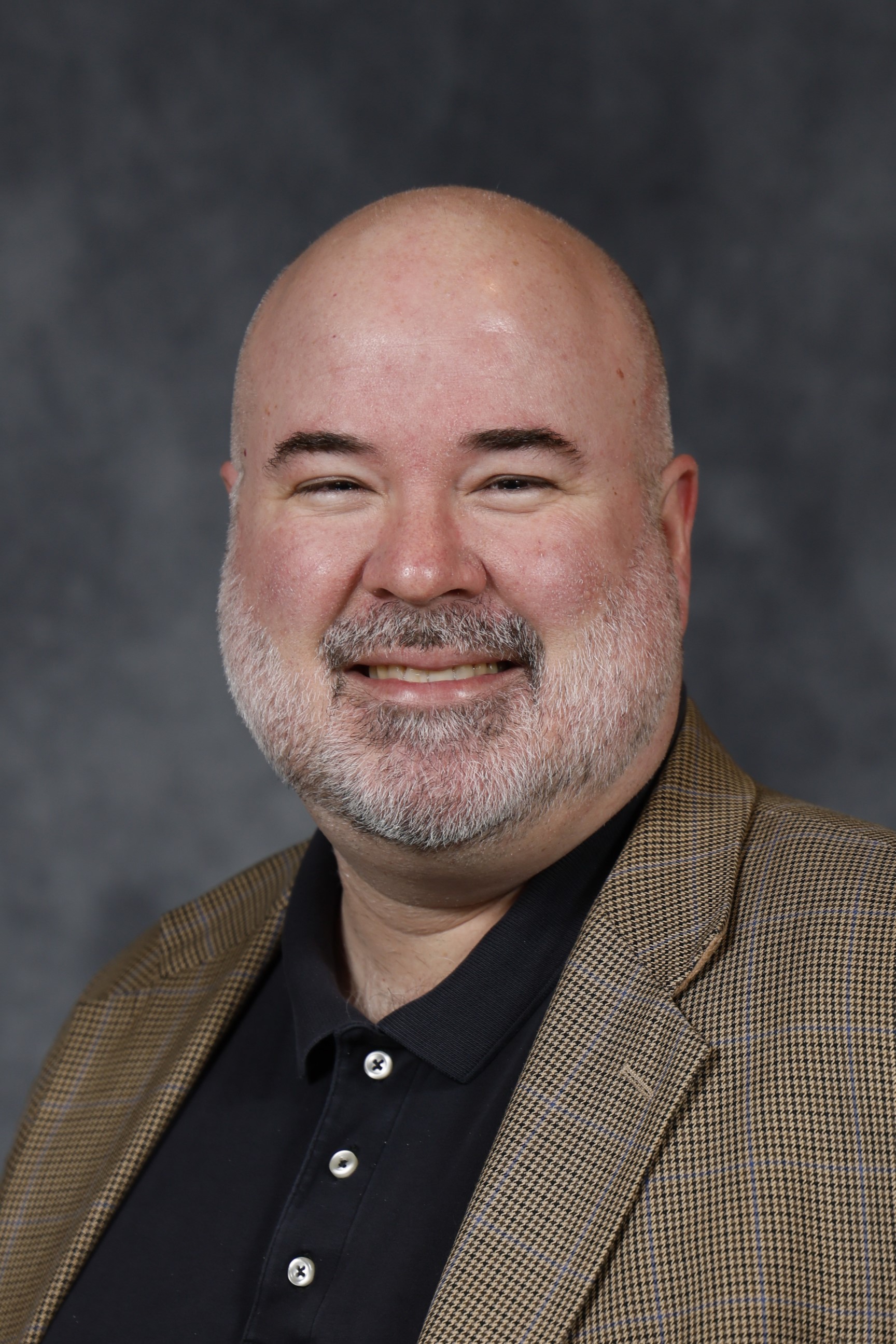 Matt Swift in brown blazer and a black shirt