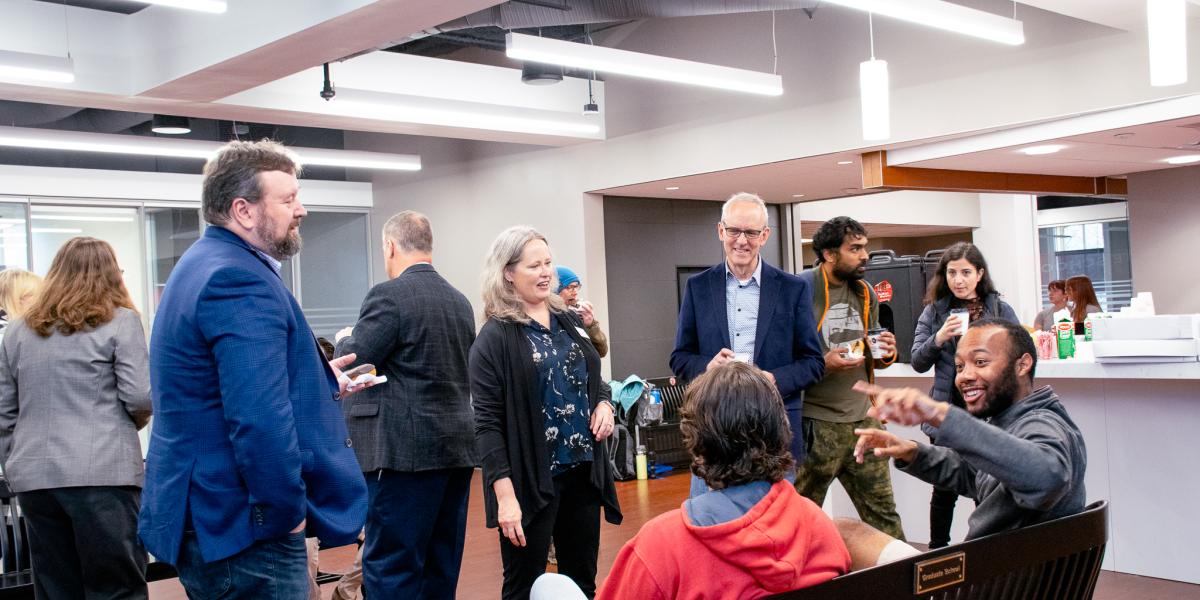 Graduate Students enjoying donuts and coffee while conversing with various Ohio State Deans including Dean Stromberger and Dean Horn