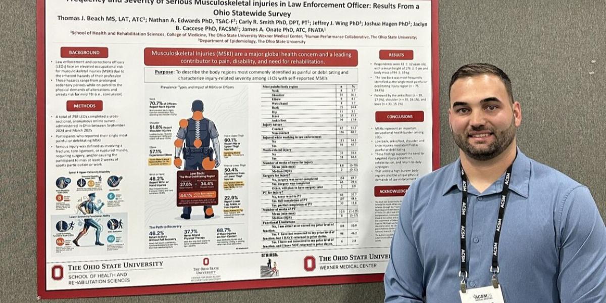Thomas Beach standing next to a research poster as a poster presentation