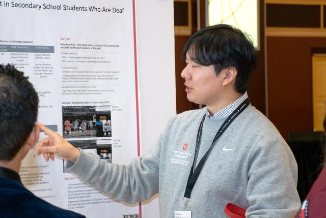 Graduate student presenting to judges during the poster presentation competition.