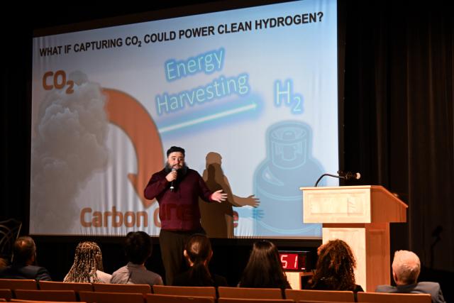 Tomaz Neves Garcia on stage presenting