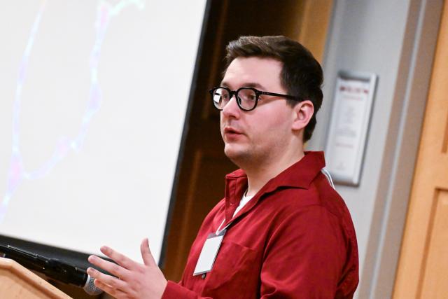 Neuroscience graduate student Jake Willows presenting behind a podium