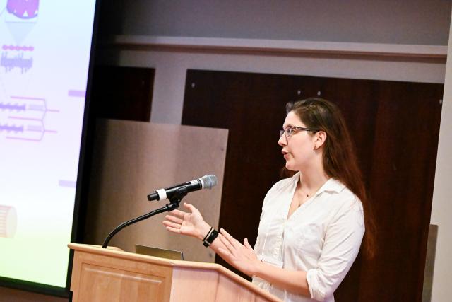Biophysics Graduate Program student Jenna Thuma presenting behind a podium