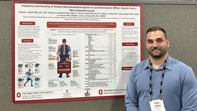 Thomas Beach standing next to a research poster as a poster presentation