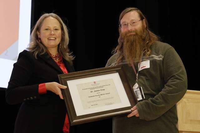 James Cray Jr. receiving the Graduate Faculty mentorship award certificate from Dean Stromberger