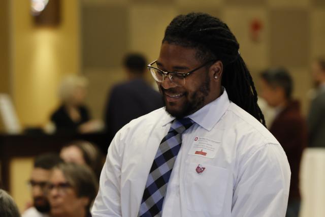 Graduate student standing to be recognized at the award ceremony