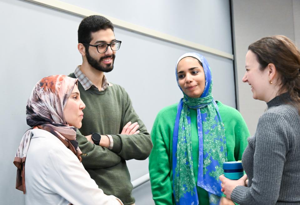 3 grad students speaking with one of their advisors