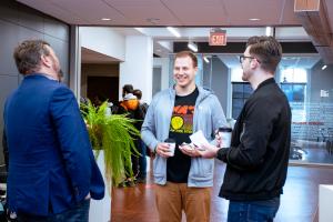 Two Graduate Students laughing and speaking to an Ohio State Dean at the Donuts with the Deans event.