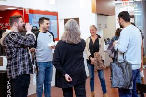 Group of Graduate Students standing ina  circle laughing and speaking with Dean Stromberger, Associate Dean Renga and current Council of Graduate Students President Jorge.