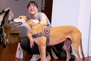 Katie Conner from the Council of Graduate Students petting the greyhound therapy dog at the Donuts with the appreciation week kick off events.