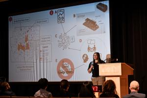 Opal Moore presenting on a stage in front of a presentation