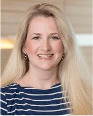 A photo of Jenny Barker smiling wearing a blue and white horizontal striped sweater.