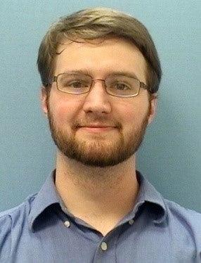 Photo of Nicholas Boyer smiling wearing glasses and a blue dress shirt