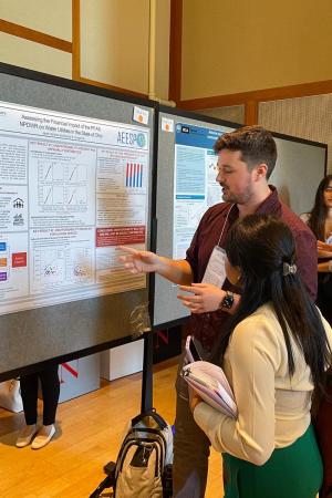 Gardner discussing research at a poster presentation