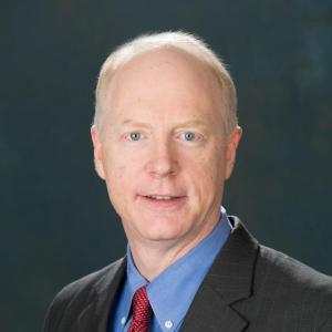 Mark Hedein portrait in a dark suit with blue shirt