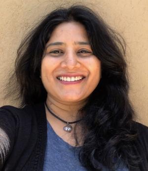 Portrait of Jayshree Gururaj in a blue shirt and black jacket