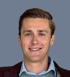 A photo of Joe Maffly-Kipp smiling wearing a blue dressh shirt and black blazer.