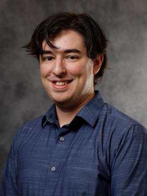 portrait of Joe Kanlong in dark short on grey background