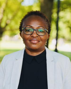 Cecilia Mengo in a white blazer and black shirt outside