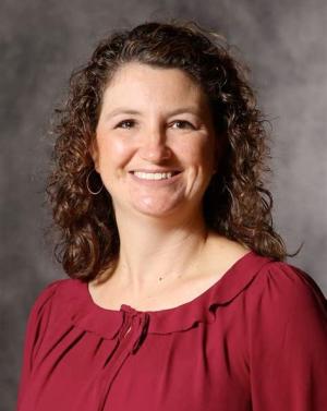 A photo of Marliese Nist smiling wearing a red blouse.