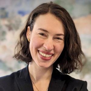 A photo of Andrea Rissing smiling wearing a black blazer.