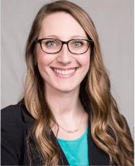 A photo of Rosie Shrout smiling wearing glasses, a black blazer and teal blouse.