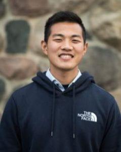 A photo of James Tan smiling wearing a dark blue hoodie.