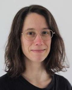 A photo of Marion Urvoy smiling wearing a black shirt and glasses.