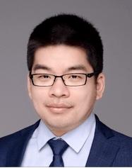 A photo of Tianlin Wang smiling wearing a glases, blue blazer, dress shirt and tie.