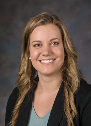 A photo of Adrien Winning smiling wearing a teal blouse and black blazer.