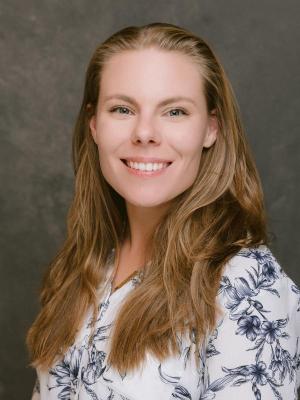 Calli Bellinger professional portrait in a white shirt on a grey background