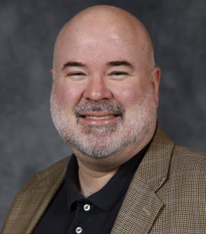 Matt Swift in brown blazer and a black shirt